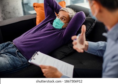 Mid Adult Man Wearing Protective Face Mask While Talking About His Problems With Mental Health Professional. 