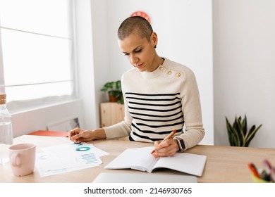 Mid Adult Woman Analyzing And Reviewing Paperwork While Working From Home. Home Office And Business Concept.