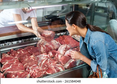 Mid adult woman buying fresh red meat in butchery - Powered by Shutterstock