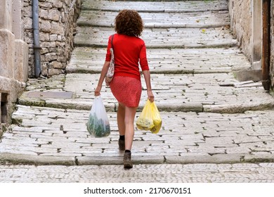 Mid Adult Woman Carrying Fresh Food From Local Market In Hands While Walking Home