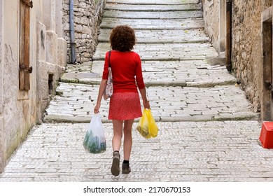 Mid Adult Woman Carrying Fresh Food From Local Market In Hands While Walking Home