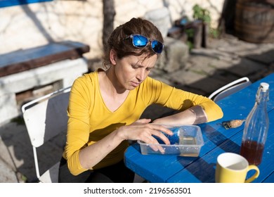 Mid Adult Woman Cools Her Finger In Cold Water After A Minor Injury Outside