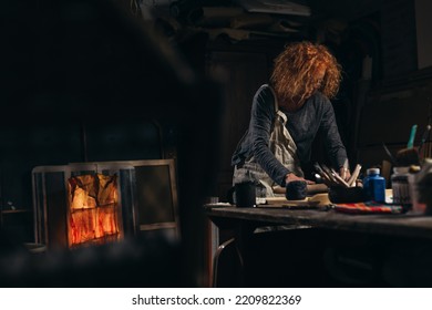 Mid Adult Woman Craftsman Working With Pottery In Her Work Shop