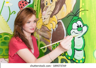 Mid Adult Woman Drawing On The Wall,mural Art.Cartoon Theme