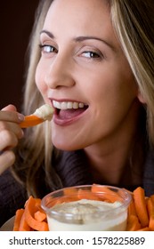 A Mid Adult Woman Eating Crudites And Dips