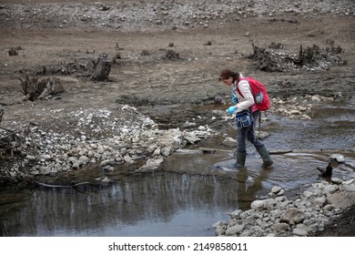 Mid Adult Woman Environmentalist Researching Riverbed Of A Dried Artificial Lake