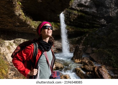 Mid Adult Woman Hiker Enjoying Sunbath In Face Near Small Waterfall