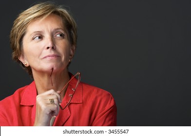 Mid Adult Woman Holding Glasses And Looking Sidewards