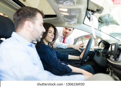 Mid Adult Woman Impressed With Car's Comfortable Interior In Auto Dealership