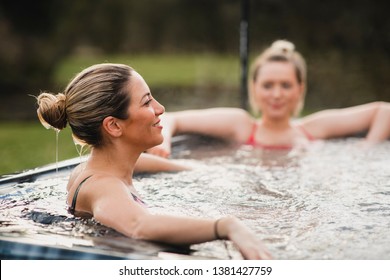 Mid adult woman relaxing in a hot tub with her friends. - Shutterstock ID 1381427759