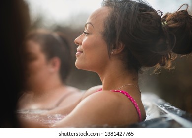 Mid Adult Woman Relaxing In A Hot Tub With Her Friends.