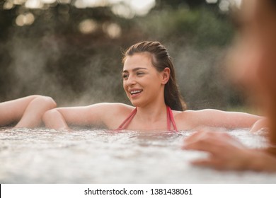 Mid Adult Woman Relaxing In A Hot Tub With Her Friends.