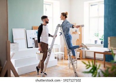 Mid Adults Couple Painting Furniture Indoors At Home, Relocation And Diy Concept.