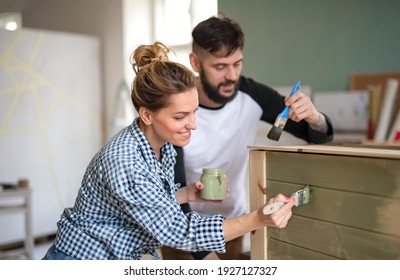 Mid Adults Couple Painting Furniture Indoors At Home, Relocation And Diy Concept.