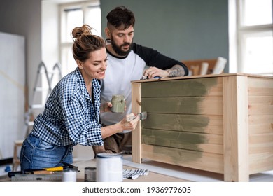 Mid Adults Couple Painting Furniture Indoors At Home, Relocation And Diy Concept.