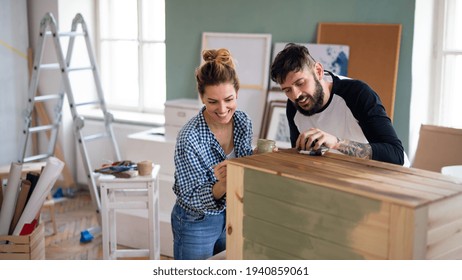 Mid Adults Couple Painting Furniture Indoors At Home, Relocation And Diy Concept.