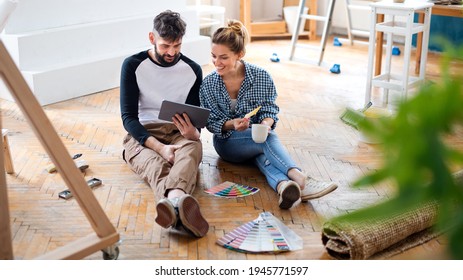 Mid Adults Couple Planning With Tablet Indoors At Home, Relocation And Diy Concept.