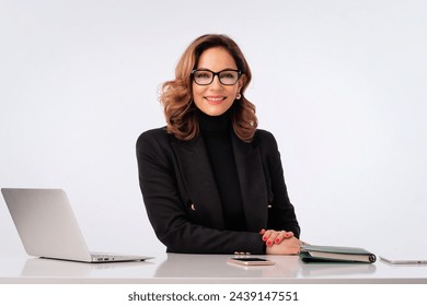 Mid age businesswoman sitting at desk against isolated white background. Confident professional female using laptop for work. Copy space. - Powered by Shutterstock