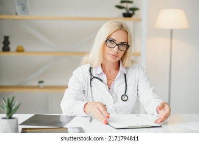 Mid Age Female Doctor Writing Prescription.