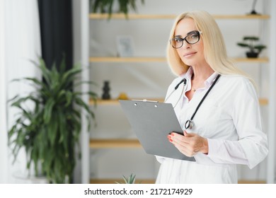 Mid Age Female Doctor Writing Prescription.