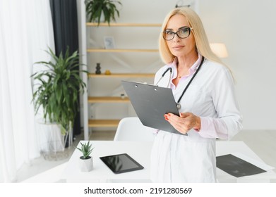 Mid Age Female Doctor Writing Prescription.