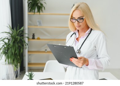 Mid Age Female Doctor Writing Prescription.