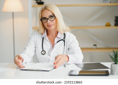 Mid Age Female Doctor Writing Prescription.