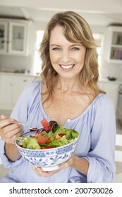 Mid Age Woman Eating Salad