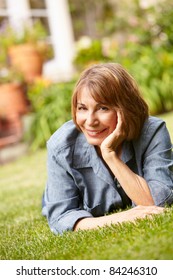 Mid Age Woman Relaxing In Garden