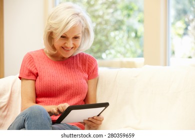 Mid Age Woman Using Tablet At Home