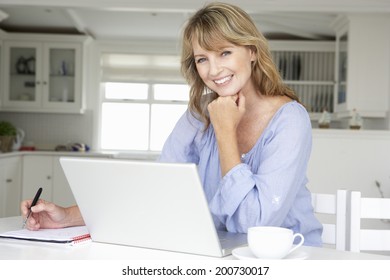 Mid Age Woman Working At Home On Laptop