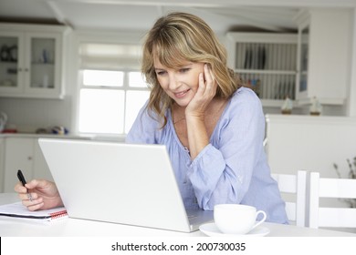 Mid Age Woman Working At Home On Laptop