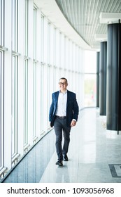 Mid Aged Business Man Walking Towards The Camera And Smiling In Office Building