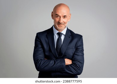 Mid aged businessman standing against isolated background. Confident man wearing suit and tie and looking at camera. Copy space. - Powered by Shutterstock