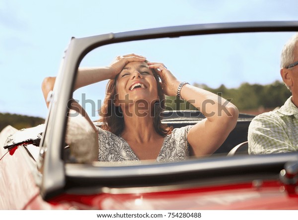 Mid aged Couple in sports\
car