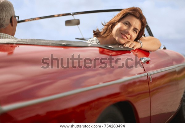 Mid aged couple in sports\
car