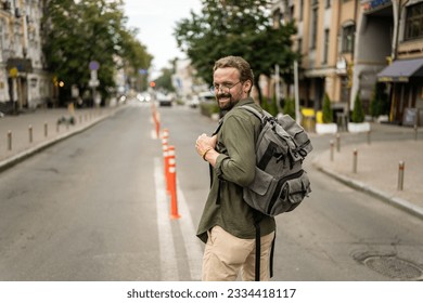 Mid aged, handsome man with backpack, ready to embark on journey and explore old city of Europe. Adventure and travel, as man prepares to immerse himself in charm and history of city. . High quality
