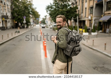 Mid aged, handsome man with backpack, ready to embark on journey and explore old city of Europe. Adventure and travel, as man prepares to immerse himself in charm and history of city. . High quality