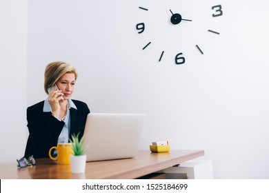 Mid Aged Woman Sitting Desk At Her Office And Talking On Mobile Phone