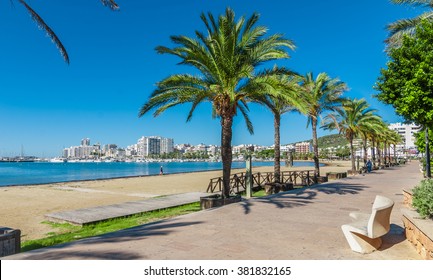 Mid Morning Sunny Day Along The Beach In Ibiza, St Antoni De Portmany Balearic Islands, Spain - City By The Bay, Row Of Palms Lines The Beach. Morning Walk In Balearic Islands