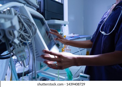 Mid section of African-american female surgeon using medical equipment in operating room of the hospital