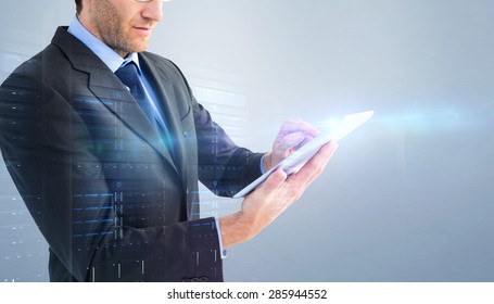 Mid section of a businessman using digital tablet against grey vignette