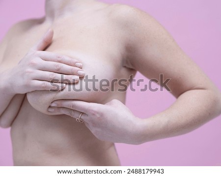 Mid section of?woman doing self breast exam