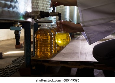 Mid section of female technician examining olive oil in factory - Powered by Shutterstock