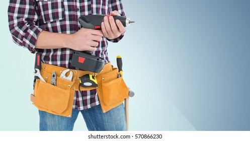 Mid Section Of Handy Man With Tool Belt Holding A Drill Against Blue Background