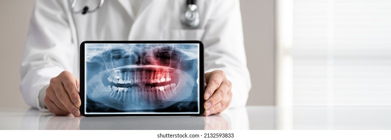 Mid Section Of Male Doctor's Hand Showing Blank White Screen Laptop On Desk - Powered by Shutterstock