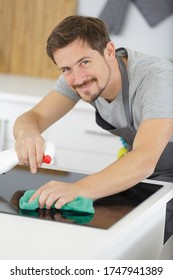 Mid Section Man Cleaning Marble Counter In Kitchen