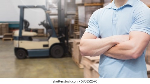 Mid section of manager standing with arms crossed in warehouse