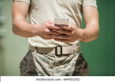 Mid Section Of Military Soldier Using Mobile Phone In Boot Camp