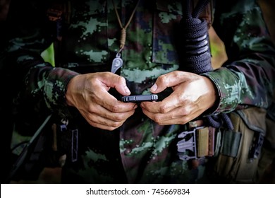 Mid section of military soldier using mobile phone in boot camp war. Historical re-enactment with a soldier and an anachronistic cell smartphone to text - Powered by Shutterstock